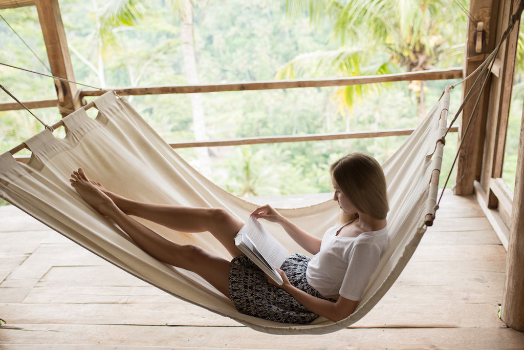 Woman reading book in hammock